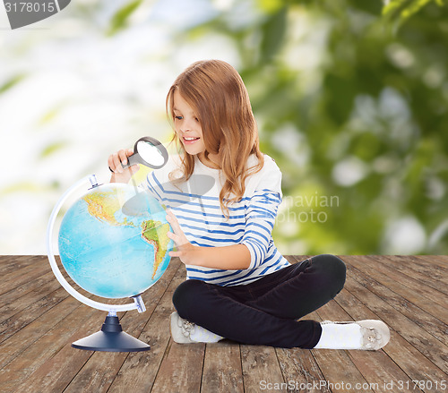 Image of happy girl looking at globe with magnifier