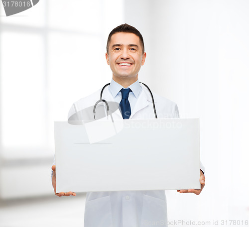 Image of smiling male doctor holding white blank board