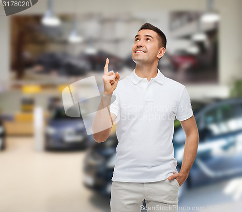 Image of smiling man pointing finger up over auto show