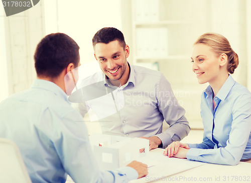 Image of couple looking at model of their house at office