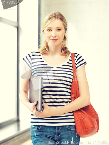 Image of happy and smiling teenage girl with laptop
