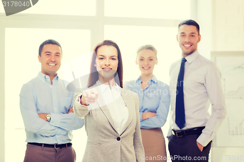 Image of businesswoman in office pointing finger at you