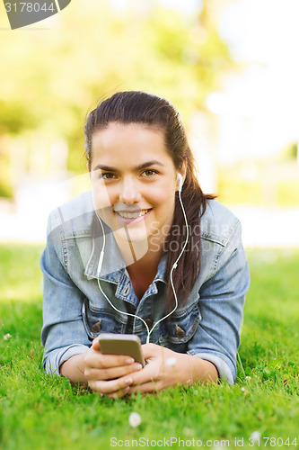 Image of smiling young girl with smartphone and earphones