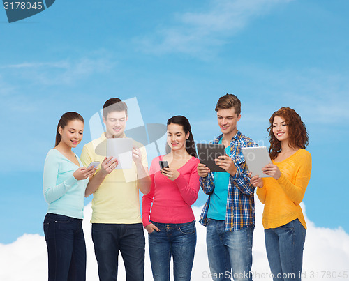 Image of group of teenagers with smartphones and tablet pc