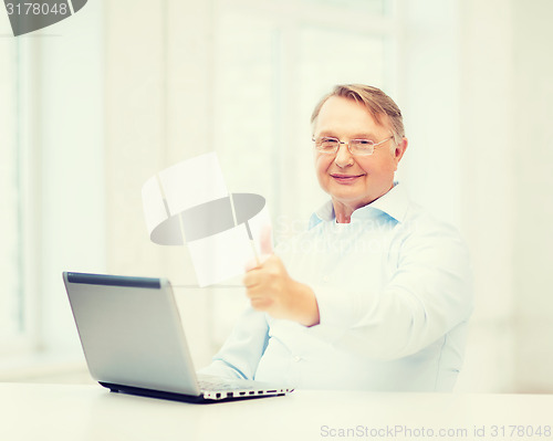 Image of old man with laptop computer showing thumbs up