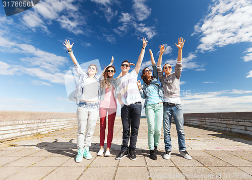 Image of group of teenagers holding hands up