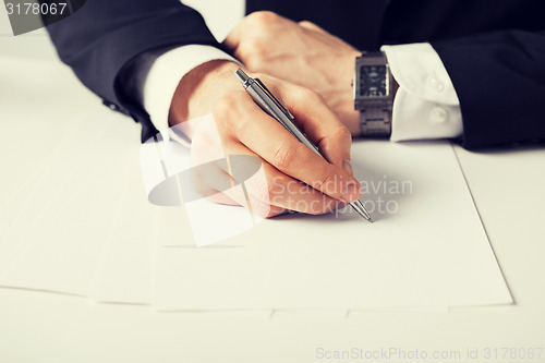 Image of businessman writing something on the paper