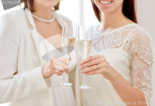 Image of close up of lesbian couple with champagne glasses