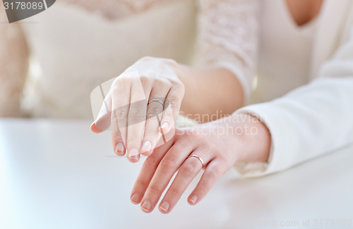 Image of close up of lesbian couple hands and wedding rings