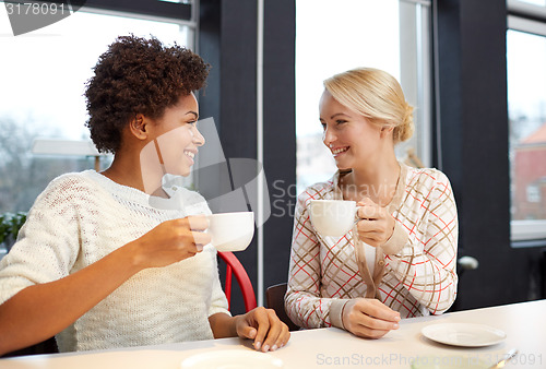 Image of happy young women drinking tea or coffee at cafe