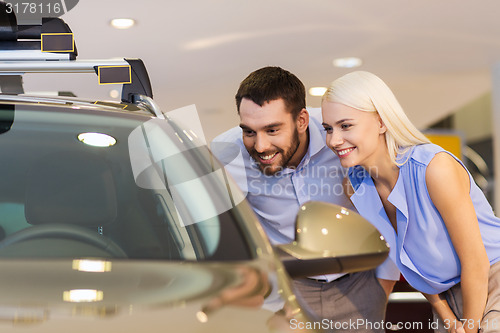 Image of happy couple buying car in auto show or salon