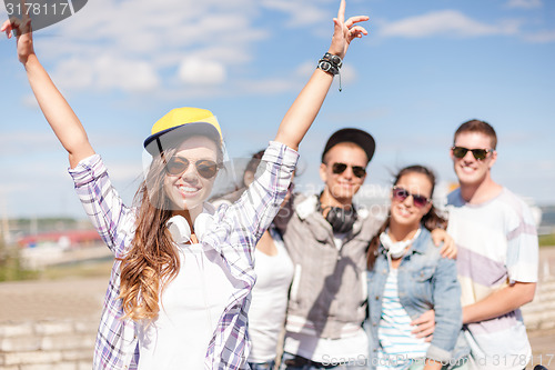 Image of teenage girl with headphones and friends outside