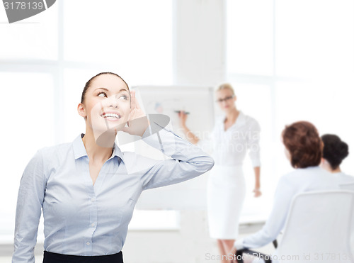 Image of smiling businesswoman listening gossig