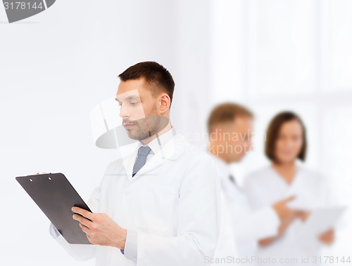 Image of serious male doctor with clipboard