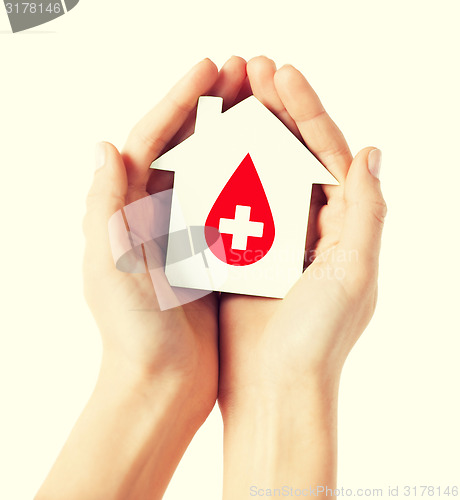 Image of hands holding house with donor sign