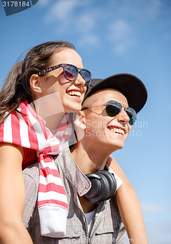 Image of smiling teenagers in sunglasses having fun outside