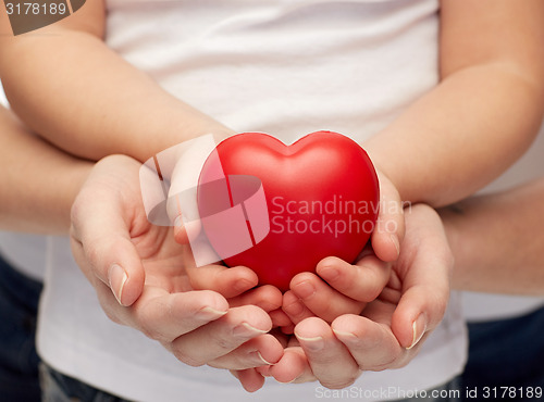 Image of close up of woman and girl hands holding heart