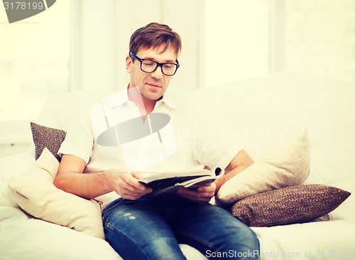 Image of man with magazine at home