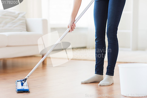 Image of close up of woman with mop cleaning floor at home