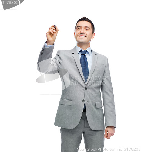 Image of happy businessman in suit writing something