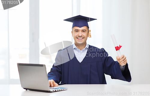Image of smiling adult student in mortarboard with diploma