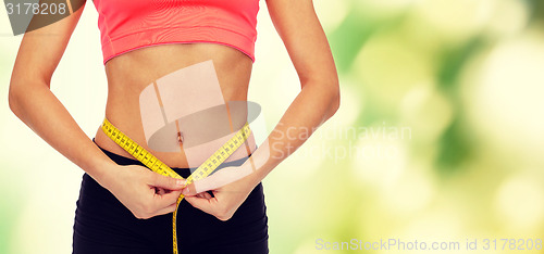 Image of close up of female hands measuring waist