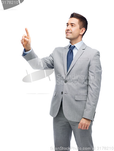 Image of happy businessman in suit touching something