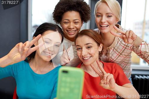 Image of happy young women taking selfie with smartphone