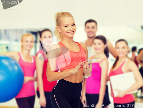 Image of smiling sporty woman with smartphone
