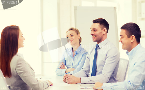 Image of smiling businesswoman at interview in office
