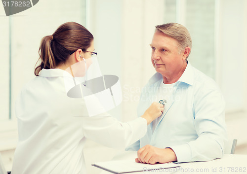 Image of female doctor with old man listening to heart beat