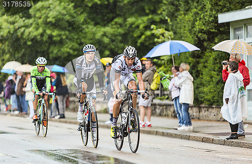 Image of Three Cyclists Riding in the Rain