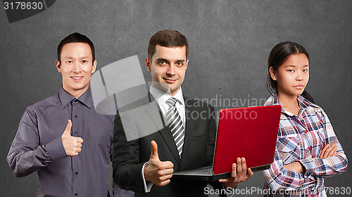 Image of Asian team and male in suit with laptop in his hands