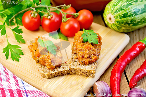 Image of Sandwich with caviar squash and red pepper on board