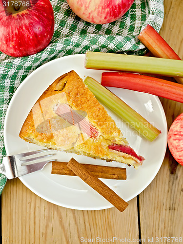 Image of Pie with apple and rhubarb in plate on wooden board