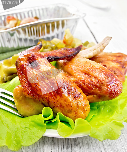 Image of Chicken wings fried in plate on board with salad