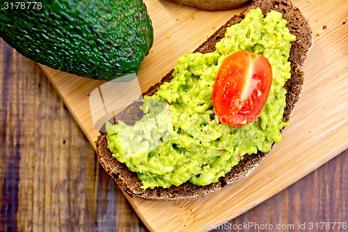 Image of Sandwich with guacamole avocado and tomato on board