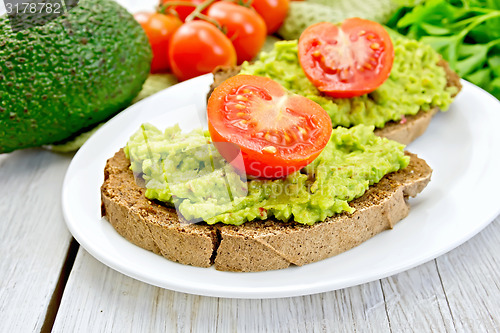 Image of Sandwich with guacamole avocado and tomato on light board