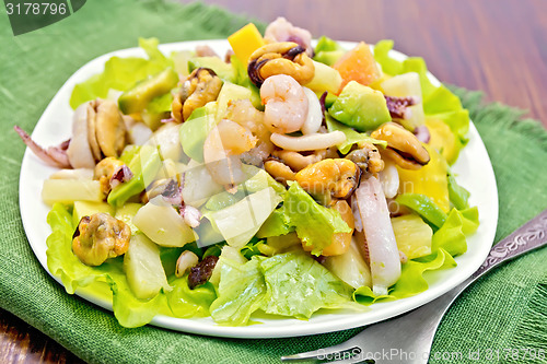 Image of Salad seafood and fork on dark board