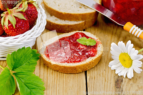 Image of Bread with strawberry jam and chamomile on board