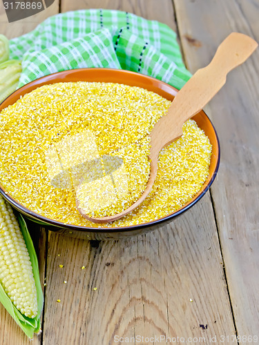 Image of Corn grits with cob and spoon on board