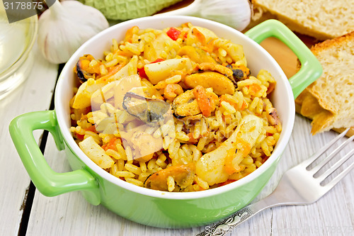 Image of Pilaf with seafood and fork on board