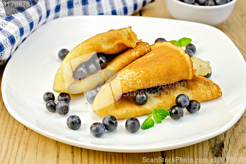 Image of Pancakes with blueberries and napkin on board