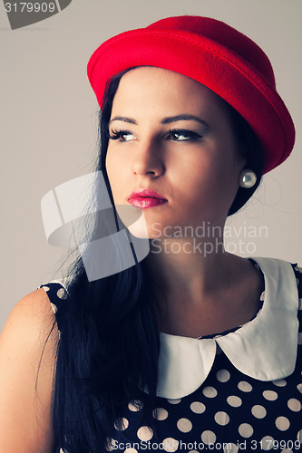 Image of Young woman with thoughtful look in red hat