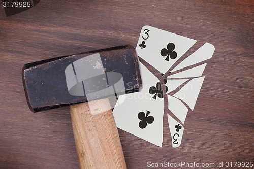 Image of Hammer with a broken card, three of clubs