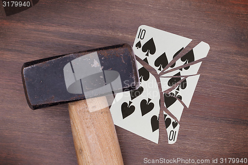 Image of Hammer with a broken card, ten of spades