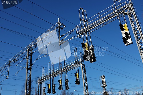 Image of train station and lines with electricity pylon against sky