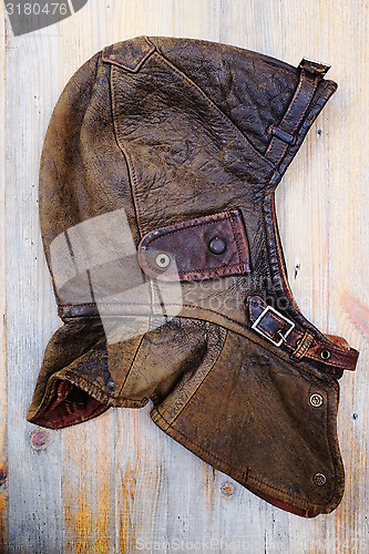 Image of leather vintage helmet over wooden background