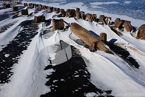 Image of remains of a wooden pier in the ice on lake
