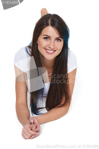 Image of Smiling beautiful woman lying on the floor